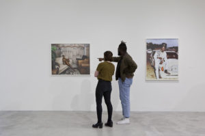 Two visitors looking at Deana Lawson's photographs
