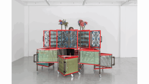 Haegue Yang, <i>Dress Vehicle – Yin Yang</i>, 2012. Aluminum venetian blinds, powder-coated aluminum frame, powder-coated handles, casters, magnets, knitting yarn, bells, elastic cord, 221 x 310 x 310 cm. Collection of M+, Hong Kong. Installation view of <i>Haegue Yang: Ajar</i>, La Douane, Galerie Chantal Crousel, Paris, France, 2012. Photo: Florian Kleinefenn.